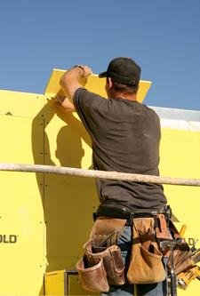 Worker installing insulation board